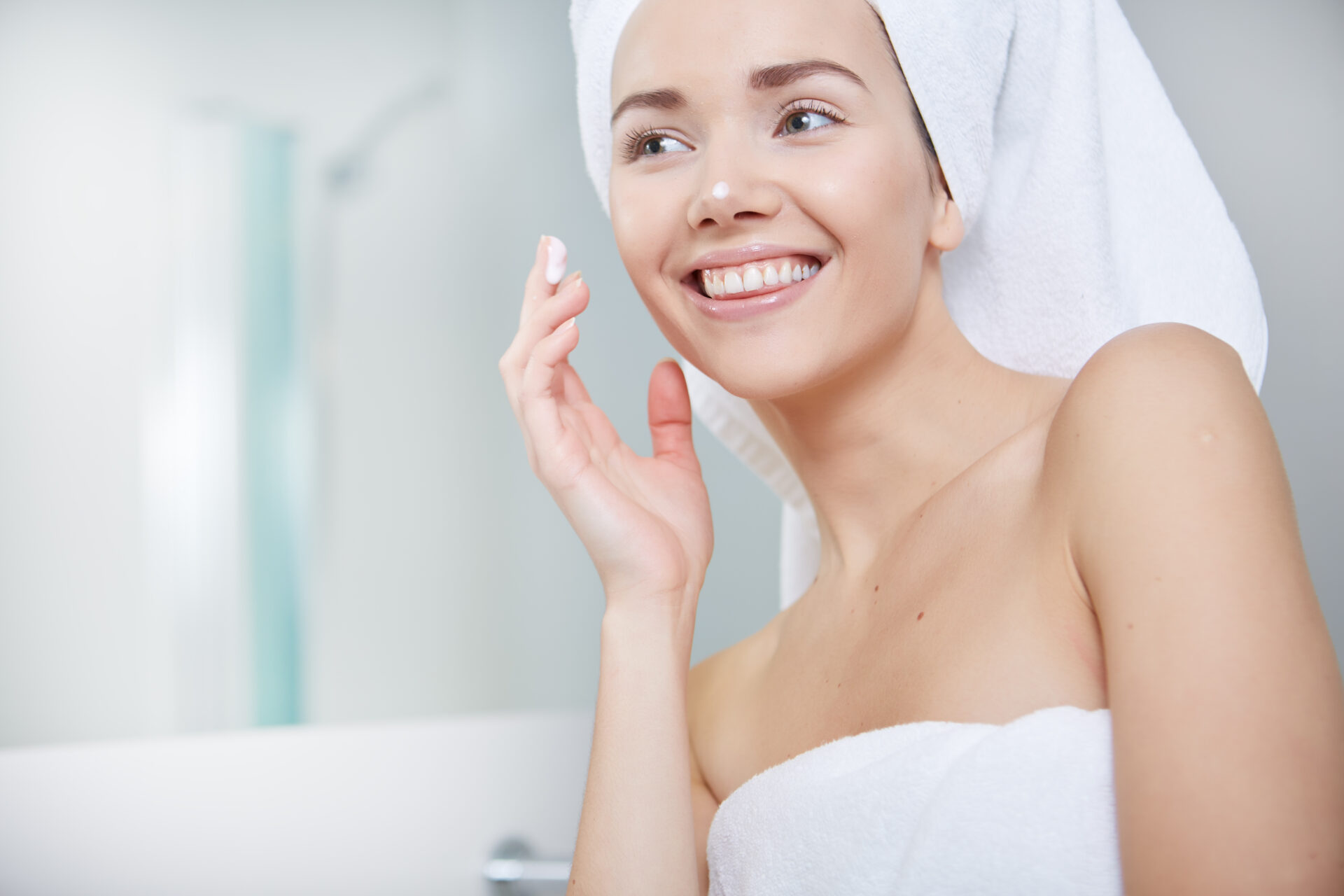 Young Woman Wrapped with Bath Towels, Applying Cream on her Face